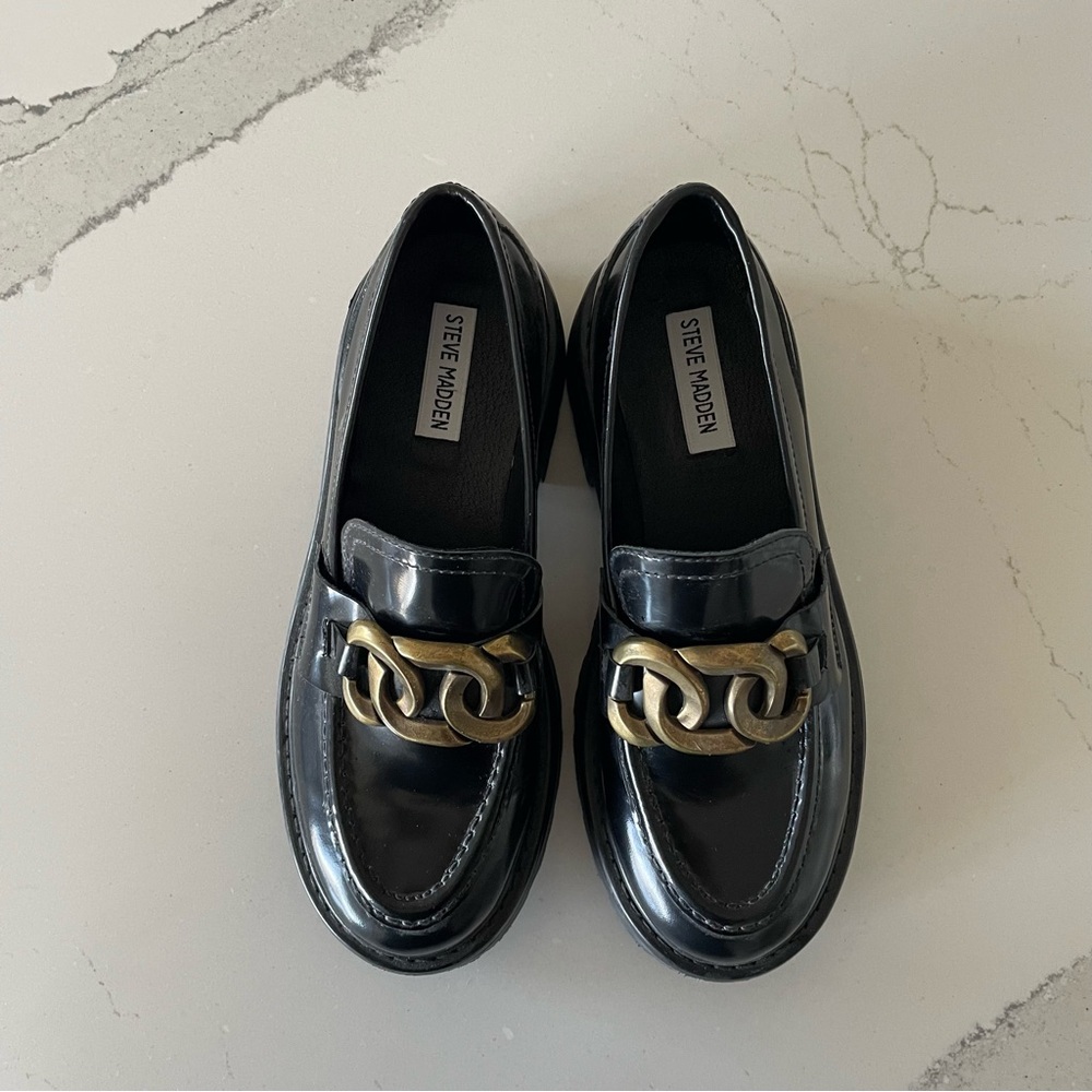 Black chunky loafers with a gold chain detail